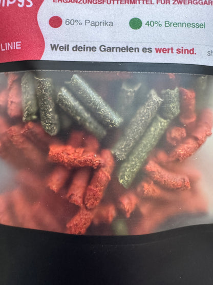SHRIMPYS® FirePott Detail – Paprika- und Brennessel-Pellets im Sichtfenster der Verpackung, vegan & natürlich | Garnelen-Pott